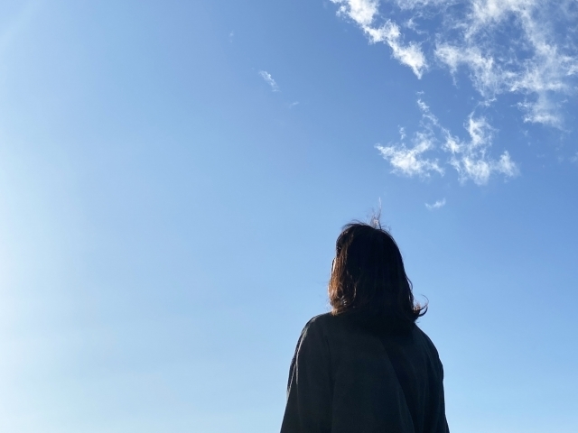 空を見つめる女性の写真