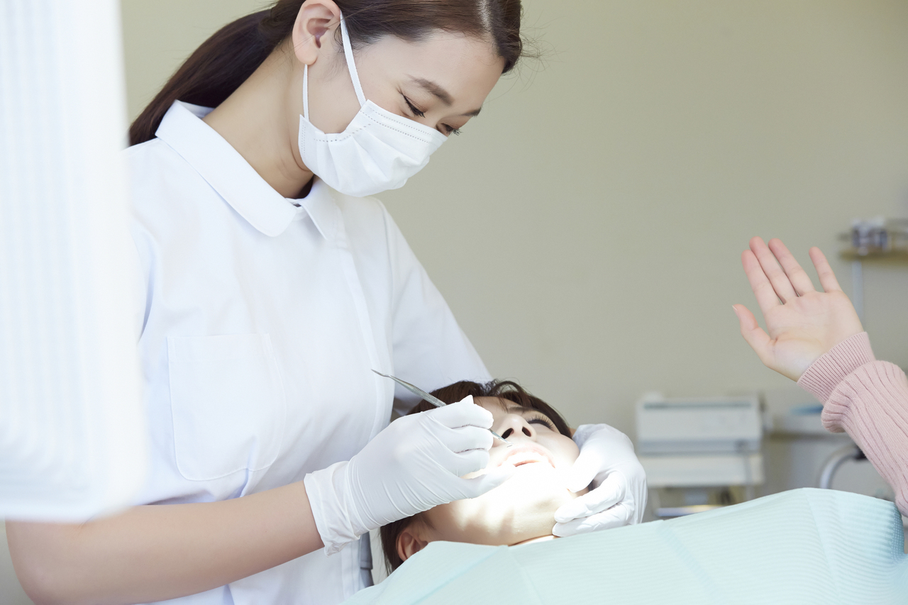 歯科衛生士が歯石を取っている画像